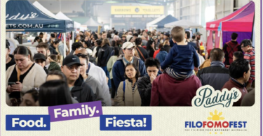 Crowded outdoor festival scene with diverse attendees, vendor tents, and banners for Food. Family. Fiesta! and Paddy's branding amid the crowd.
