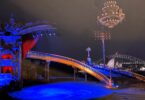 Ornate circus-style stage with gilded sculptures, red velvet curtains, and a blue-lit circular pool at night awaiting performance.