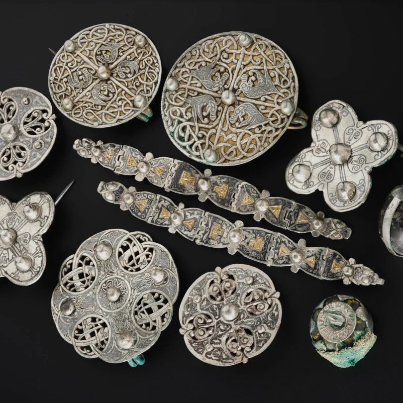 Assorted circular metal discs with intricate Celtic knotwork on a black background.
